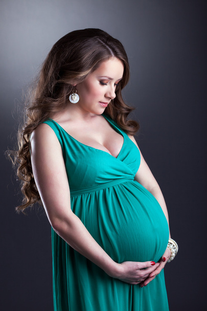 Pretty pregnant woman caressing her belly - Foto, imagen