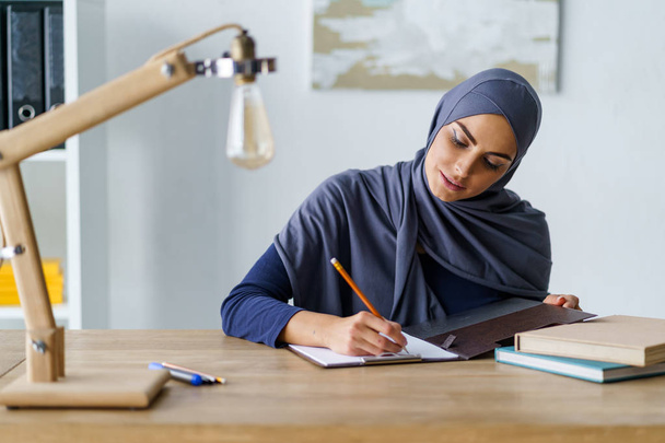 Muslim woman sketching with pencil - Фото, зображення