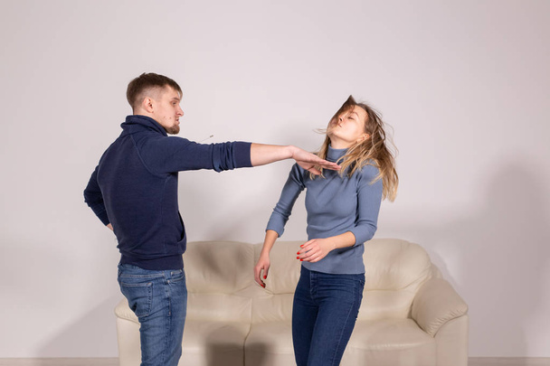 people, violence and abuse concept - angry man hitting woman in her face on sofa - Photo, Image
