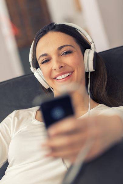 Relaxed woman listening to music in the living-room at home - Φωτογραφία, εικόνα