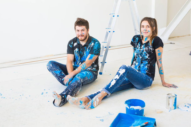 Mensen, herinrichting en relatie concept - jonge grappige paar doen renovatie in nieuw appartement en plezier hebben op het einde - Foto, afbeelding