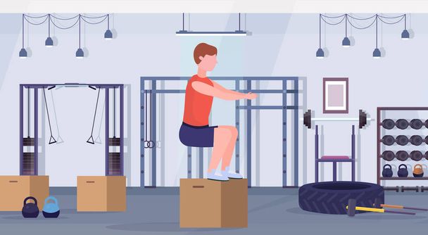 sports man doing box squat exercises guy jumping working out in gym crossfit healthy lifestyle concept modern health club studio interior horizontal - Vettoriali, immagini
