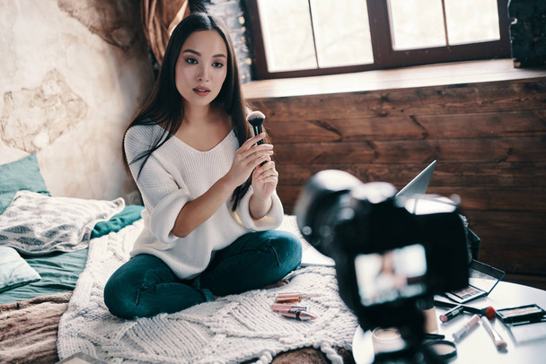 Must have thing. Beautiful young woman testing beauty product while making social media video - Zdjęcie, obraz