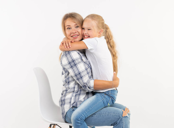 Материнство, семья и отношения концепция - Счастливая мать и маленькая дочь веселятся на белом фоне
 - Фото, изображение