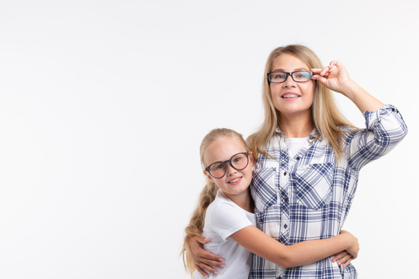 Χαρούμενος νεαρή μητέρα και γέλιο παιδί γυαλιά μόδας έχουν διασκέδαση σε λευκό φόντο - Φωτογραφία, εικόνα