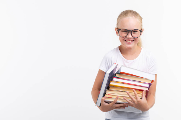 Eğitim, insanlar, çocuklar ve okul kavramı - gözlük tutan okul öğrenci ellerinde kopya alanı beyaz zemin üzerine kitaplar - Fotoğraf, Görsel