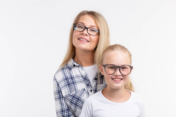 Portrait of mother and daughter with eyeglasses on white background - Photo, Image