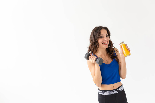 Sağlıklı yaşam, insanlar ve spor kavram - spor ve fitness kopya alanı ile beyaz arka plan üzerinde içki sağlıklı meyve suları kadınla - Fotoğraf, Görsel