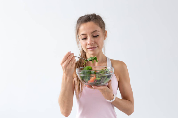 Lidé, jídlo a dieta koncept - portrét ženy, jíst zdravé jídlo nad bílým pozadím - Fotografie, Obrázek