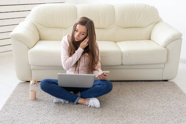 Технології, концепція фрілансу та людей - молода жінка працює вдома, вона п'є воду на підлозі, спілкується в ноутбуці
 - Фото, зображення