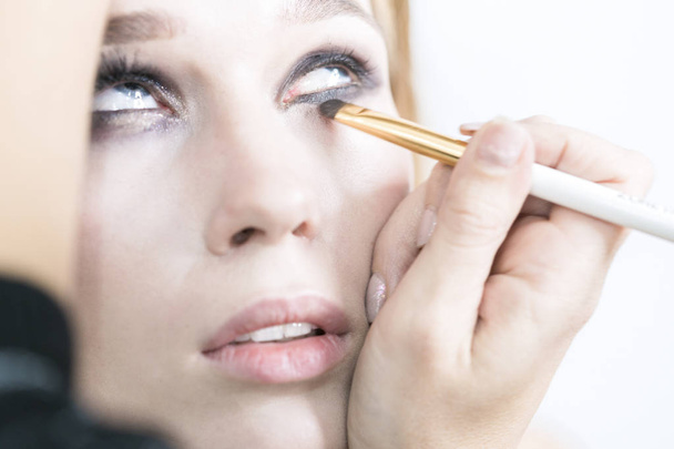 Makeup close up. Makeup artist performs eye makeup - Φωτογραφία, εικόνα