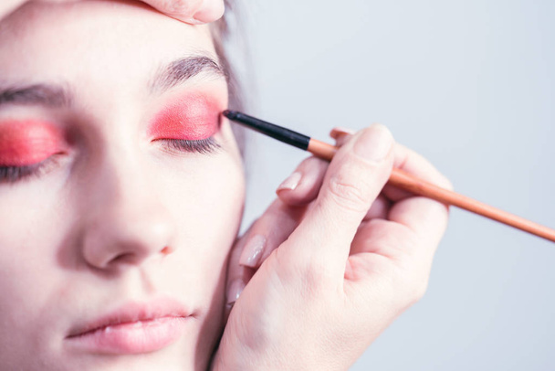 Makeup artist performs bright eye makeup in the studio. Close-up - Fotoğraf, Görsel