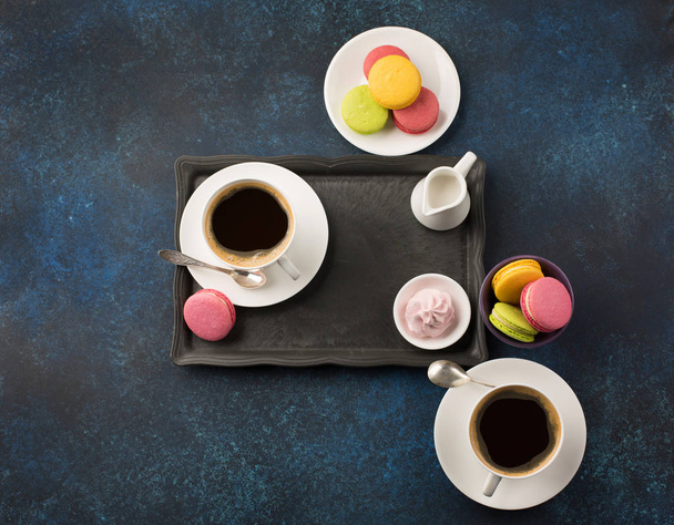Twee kopjes koffie en zoetigheden op tafel - Foto, afbeelding