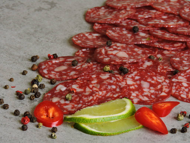 Salami with lime and pepper. Top view. Background. - Foto, Imagem