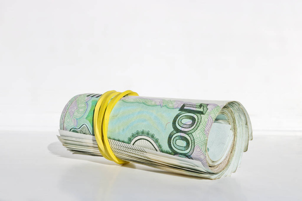 1000 Rublesi faturaları bir paket bir tüpün içine katlanmış ve elastik bant tarafından ele. - Fotoğraf, Görsel