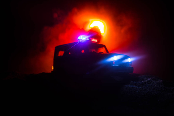 Poliisiautoja öisin. Poliisiauto jahtaa yöllä autoa, jolla on sumutausta. Hätäkeskus. Poliisiauto ajaa ylinopeutta rikospaikalle. Valikoiva painopiste - Valokuva, kuva