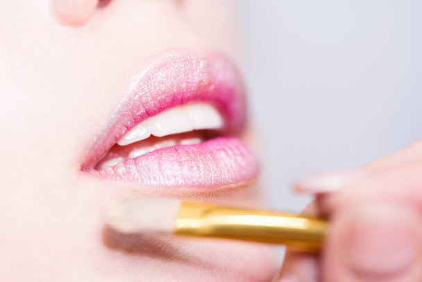 Close up of applying pink glittering model lipstick - Фото, зображення