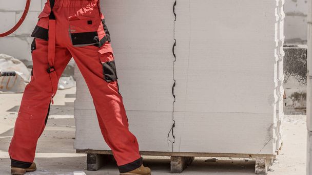 Person wearing red worker trousers - Foto, Imagen