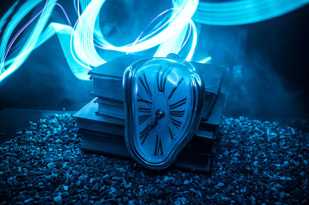 Концепция времени. Искаженные мягкие плавильные часы на старых книгах. На темном туманном фоне. Селективный фокус
 - Фото, изображение