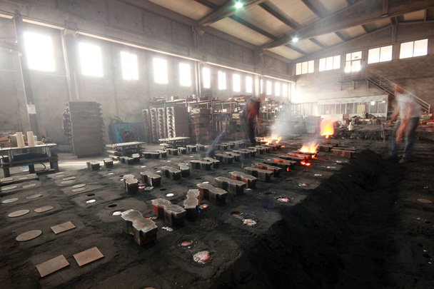 workers in a foundry at the melting furnace - Photo, Image