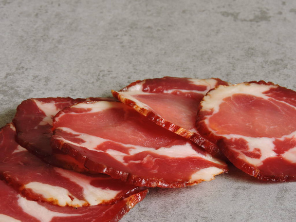 Smoked pork thinly sliced. Circles of smoked pork. - Photo, Image