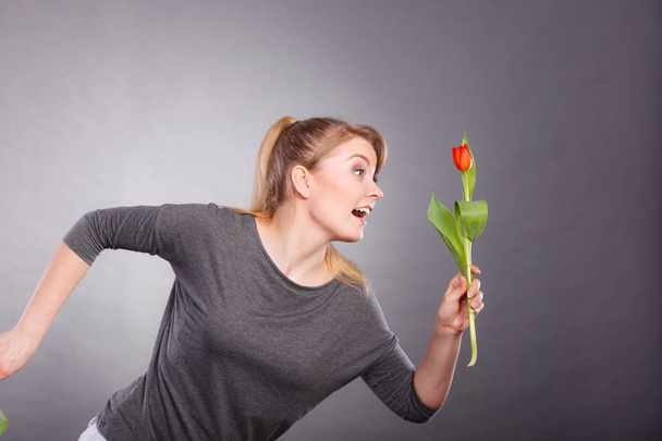 Playful girl having fun with flower tulip. - Zdjęcie, obraz