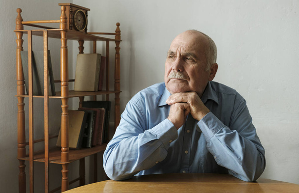 Bir tablo düşünce oturan yaşlı adam - Fotoğraf, Görsel
