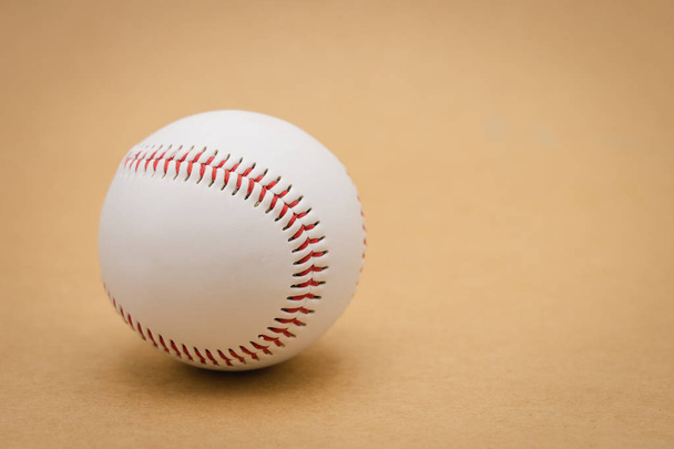Ізольований бейсбол на коричневому фоні і червоний зшитий басеба
 - Фото, зображення