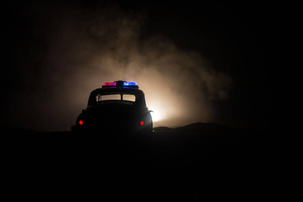 Police cars at night. Police car chasing a car at night with fog background. 911 Emergency response police car speeding to scene of crime. Selective focus - Photo, Image