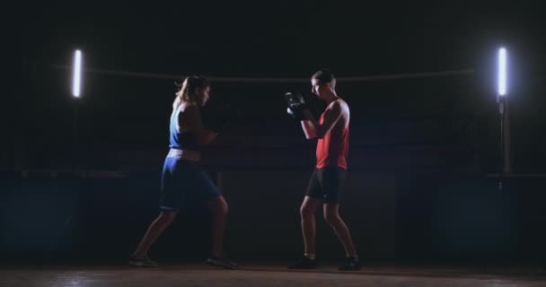 Красива жінка в кікбоксингу навчає ударів фокус кліщів у фітнес-студії запеклої міцності підходить для серії боксерів тіла
 - Кадри, відео