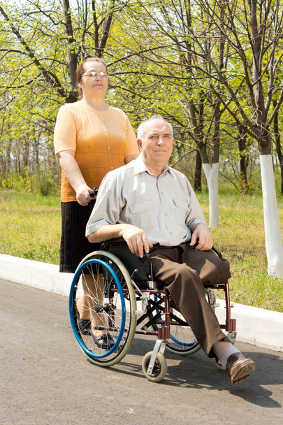 Wife taking her disabled husband for a walk - Zdjęcie, obraz