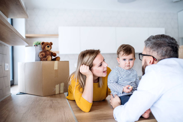 A portrait of young family with a toddler girl moving in new home. - Fotoğraf, Görsel