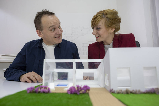 Dwóch architektów, patrząc na dom modelu w pakiecie office - Zdjęcie, obraz