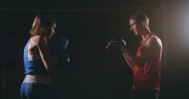 kickbokser vrouw atleet kickboksen coach opleiding van vrienden van de vrouwelijke fitness boxing bokszak focus mitts genieten van intense oefening workout samen in sportschool close-up - Video