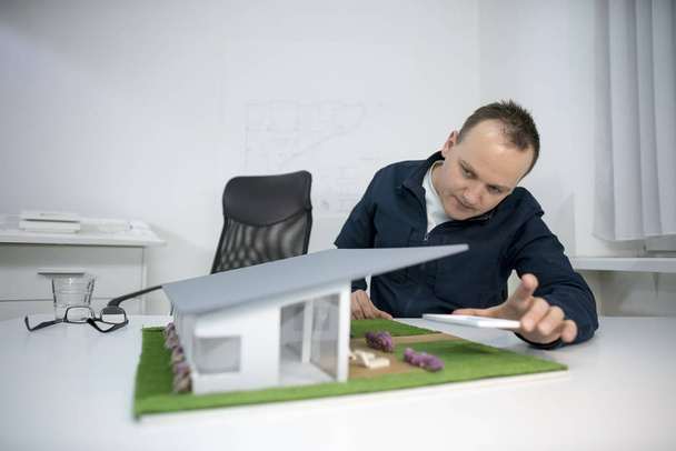 Architekt schaut sich Musterhaus im Büro an - Foto, Bild