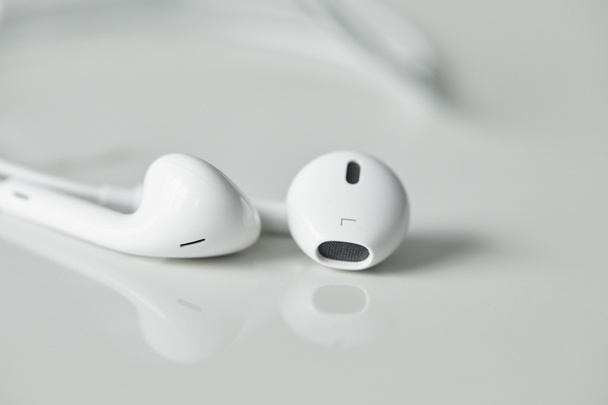 επιλεκτική εστίαση των ενσύρματων ακουστικών σε λευκή επιφάνεια με χώρο αντιγραφής - Φωτογραφία, εικόνα