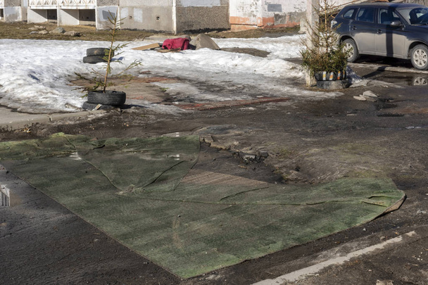 Habitantes de la ciudad cubrieron pozos de terrible camino con alfombras viejas en primavera
 - Foto, Imagen