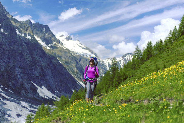 Woman hiking in mountain range. Rear view of a female backpacker - Zdjęcie, obraz