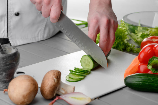 Man cutting a cucumber - Fotó, kép