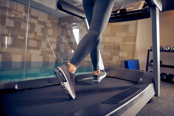Close up of woman's legs running on treadmill. Gym interior. - Photo, Image