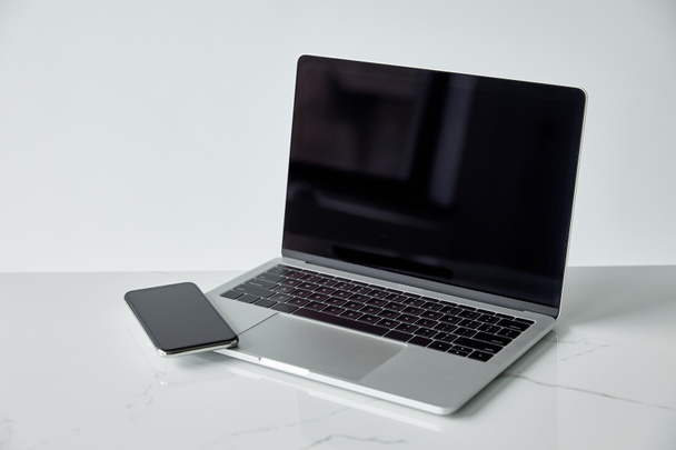 laptop and smartphone with blank screen isolated on grey with copy space - 写真・画像