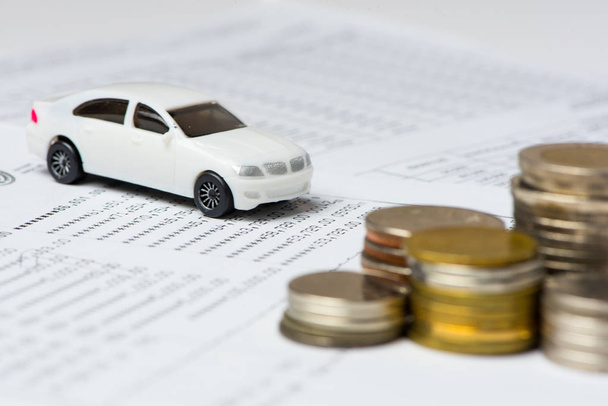White car and coins on the account book in selective focus, Concept: Buy, new car, finance, investment. - Φωτογραφία, εικόνα