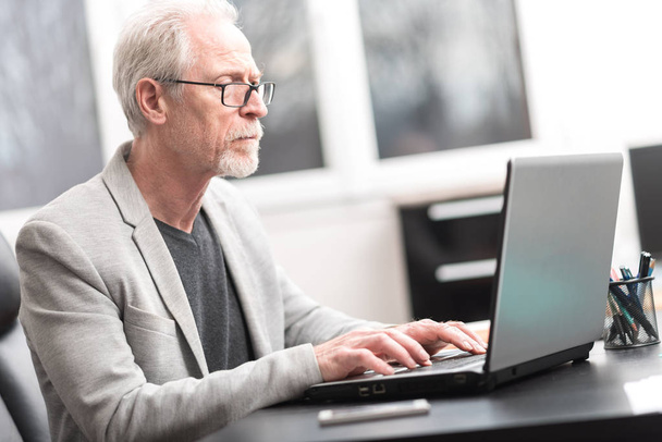 Mature businessman using laptop - Foto, afbeelding
