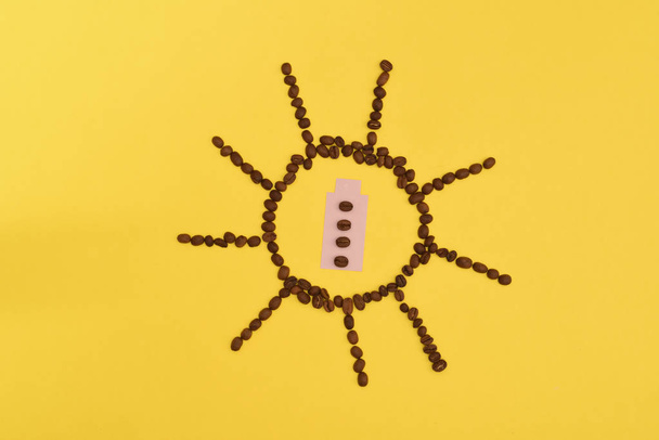 Забавное и милое солнце из кофейных зерен на желтом фоне
 - Фото, изображение
