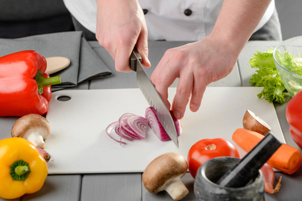 Chef slicing a red onion - 写真・画像