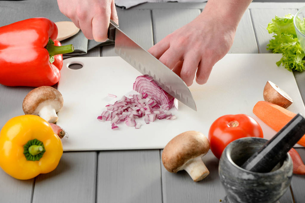Man finely chopping an onion - Fotó, kép