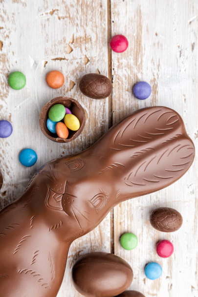 Chocolate Easter bunny, eggs and sweets on rustic background - Valokuva, kuva