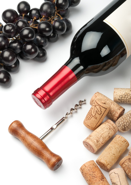 μπουκάλι κόκκινο κρασί, σταφύλια, τιρμπουσόν και πώματα σε λευκό - Φωτογραφία, εικόνα