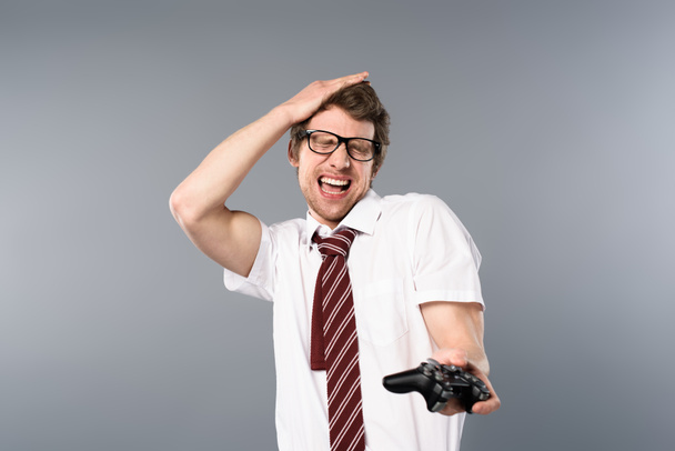 hombre de negocios emocionado con los ojos cerrados jugando videojuego con joystick sobre fondo gris
 - Foto, Imagen
