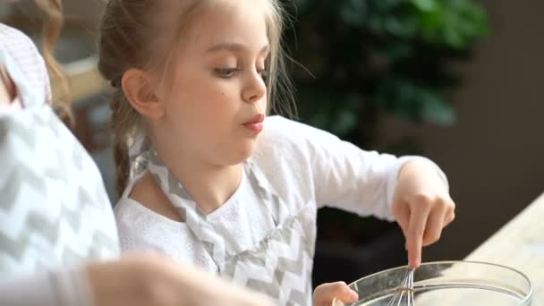 Close up. Portrait of kid girl mixing dough in the bowl.  - Imágenes, Vídeo